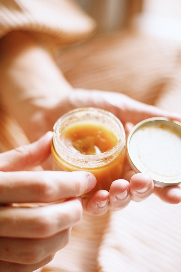 Hand holding a jar of natural skincare product highlighting eco-friendly, botanical skincare.
